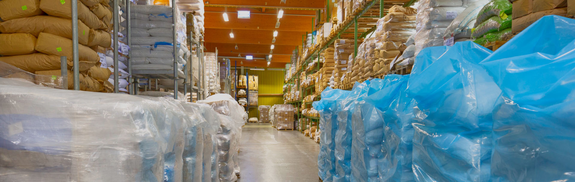 a large warehouse for raw materials in a hall with high racks in which a large number of sacks are stored